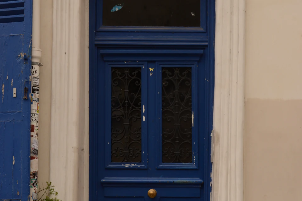 Porte bleue de style ancien sur une façade parisienne en pierre