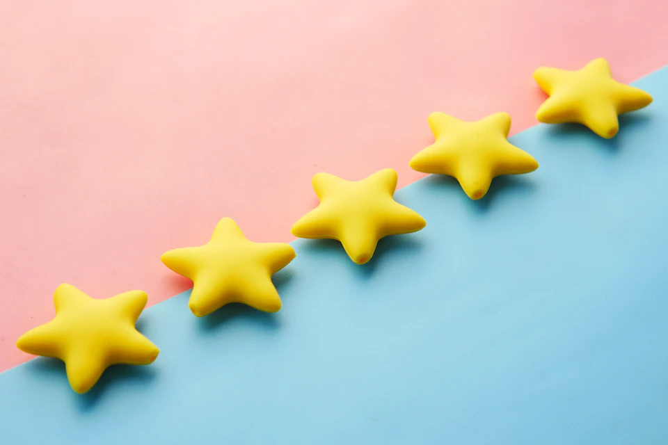 Rangée de cinq étoiles jaunes sur un fond bleu et rose