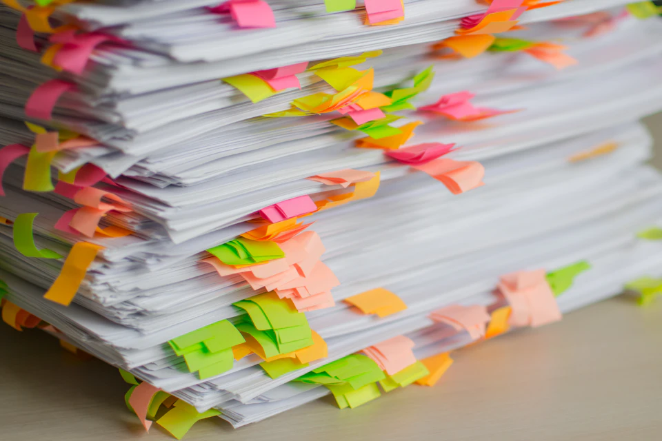Pile de documents annotés de languettes adhésives colorées