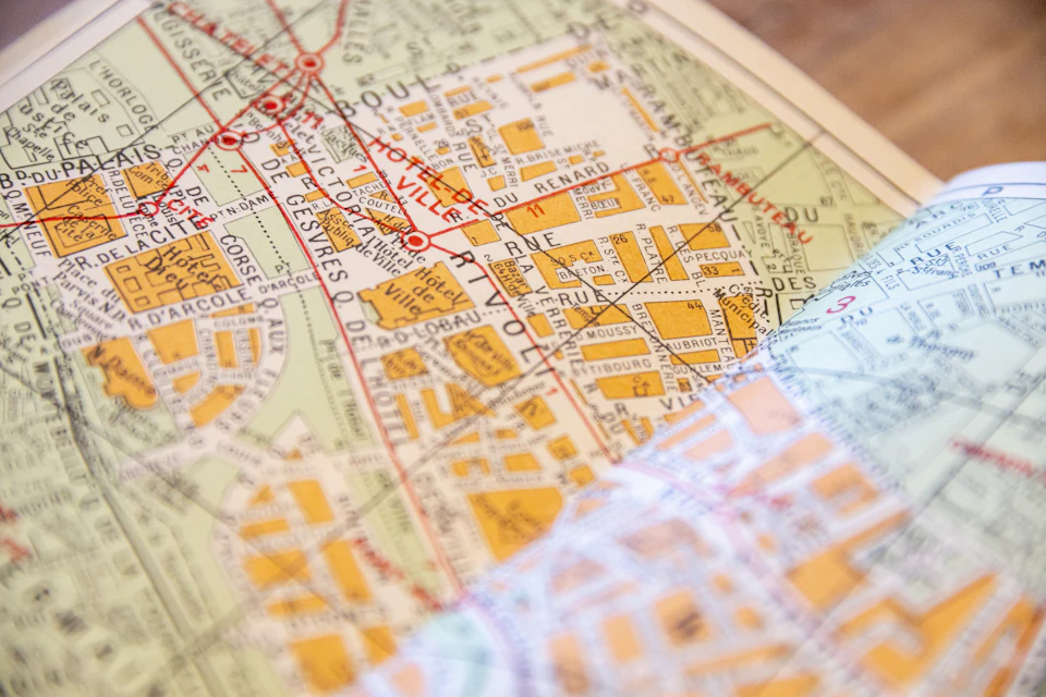 Plan de quartier papier avec rues et bâtiments posé sur une table