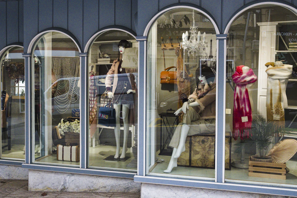 Vitrine d'une boutique aux grandes fenêtres cintrées avec des mannequins habillés